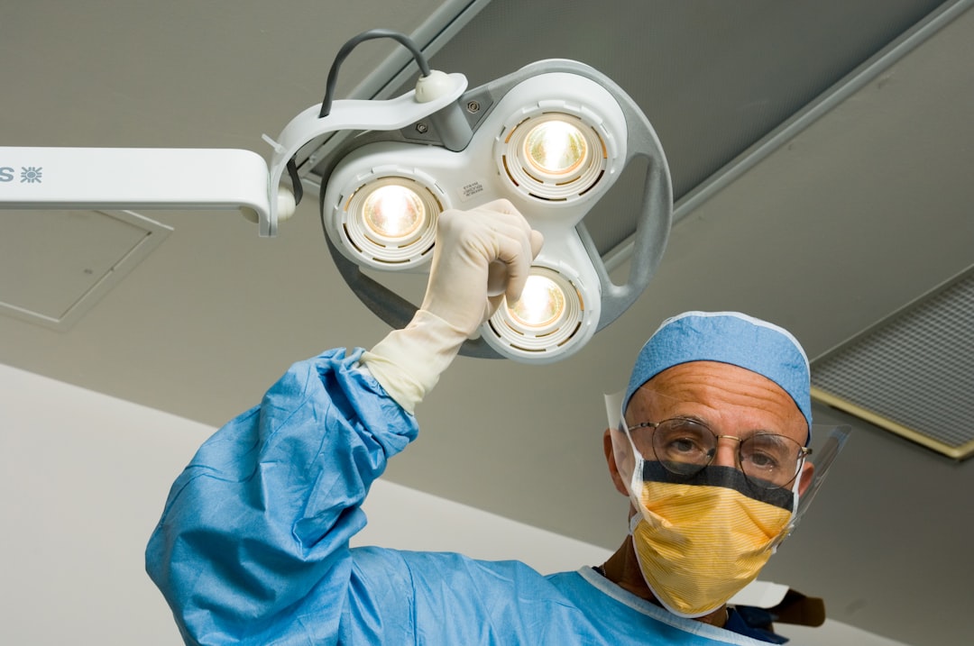 services-02 a-man-in-a-surgical-gown-holding-up-a-surgical-light-knsyar6rsug
