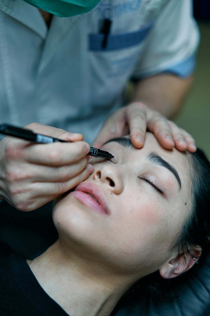 gallery-02 Cosmetologist marking eyelids for blepharoplasty on a patient.